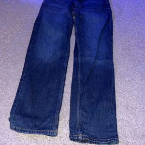 Blå jeans från H&M - Säljer ett par blå jeans från H&M med slim fit och justerbar midja. Perfekta för en stilren look.