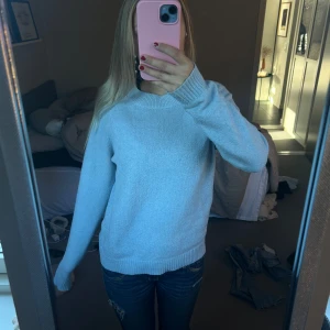 Ljusblå stickad tröja - Säljer en supermysig ljusblå stickad tröja. Den är perfekt för kyliga dagar och har en normal passform med långa ärmar. Tröjan är i bra skick och passar perfekt till jeans för en avslappnad look. Perfekt för höst och vinter!