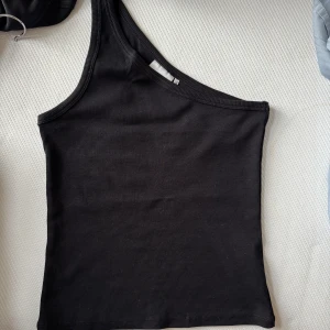 One shoulder top - Ribbat linne från Gestuz! Perfekt stretch i materialet, aldrig använt!