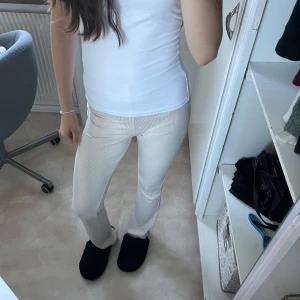Beige ribbade byxor - Säljer ett par snygga utsvängda beige ribbade byxor. De är superbekväma och har en tight passform som framhäver benen. Perfekta för både vardag och fest! 🥳
