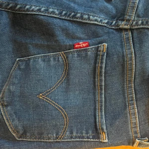 Blå jeans med hög midja - Säljer ett par snygga blå jeans från Levi's. De är högmidjade och super skinny, vilket ger en tight och smickrande passform. Perfekta för både vardag och fest! Bra skick. 