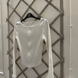 Tröja nova of sweden - Vit långärmad tröja med dragkedja framtill. Tröjan är figursydd och har en avslappnad passform. Den är välanvänd!