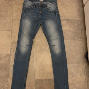 Blå jeans från Gina tricot  - Snygga blå jeans med en tight passform från Gina. De har en klassisk femficksdesign och en lätt tvättad look. Perfekta för en stilren vardagslook.