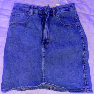 Blå jeanskjol från Zara - Snygg blå jeanskjol från Zara i en klassisk design med fem fickor och dragkedja fram. Perfekt för en avslappnad stil. Kjolen har en normal passform och är tillverkad i slitstarkt denim.