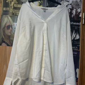 Vit blus från H&M - Säljer en stilren vit blus från H&M. Blusen har en klassisk krage och knappar framtill. Perfekt för en elegant look. Väldigt skön och silky 