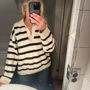 Randig tröja med krage - Säljer en mysig stickad randig tröja i beige och svart med krage och långa ärmar. 