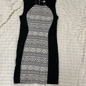 Svart och vit mönstrad klänning - Snygg ärmlös klänning med svart och vit mönstrad design. Klänningen har en tight passform och är perfekt för en stilren look. Den är tillverkad i ett mjukt och bekvämt material som formar sig väldigt fint efter kroppen. Skriv för fler bilder.
