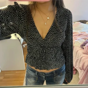 Svart blus med vita prickar - Snygg svart blus med vita prickar och v-ringning. Perfekt till alla möjliga tillfällen! ♥️