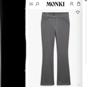 Grå kostymbyxor från Monki - Snygga grå byxor från Monki med bootcut-stil. De har en låg midja och stängs med knappar. Byxorna är bara prövade men va inte riktigt min färg 