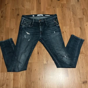 Replay anbass - Snygga mörkblå jeans från Replay med slitna detaljer i ok skick. Nypriset ligger på runt 1900kr  strlk 32:34