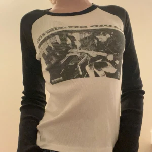 Vit och svart långärmad topp med tryck - Säljer en vit svart långärmad topp med ett  tryck på framsidan. Toppen har svarta ärmar och en rund halsringning. Från Brandy Melville har aldrig använt 