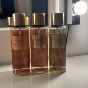 Body mist från Victoria's Secret - Tre doftsprayer från Victoria's Secret: Amber Romance, Bare Vanilla och Coconut Passion. OBS det är mindre än vad det är på bilderna. Flaskorna har en elegant design med gyllene lock och transparenta behållare som visar vätskan i olika nyanser av bärnsten och vanilj.