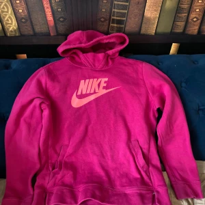 Rosa hoodie från Nike - Säljer en snygg rosa hoodie från Nike med klassisk logga på bröstet. Hoodien har en bekväm passform med känguruficka framtill och en mysig huva. Perfekt för en avslappnad stil. 💖storlek är XL men det är 156-166 cm 