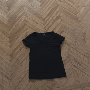 Svart t-shirt från 157 - Snygg svart t-shirt från 157 med korta ärmar. Perfekt basplagg för alla tillfällen. Enkel och stilren design som funkar året runt.