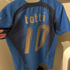 Totti (10) Italien Hemmaställ 2006 - Italiens hemmaställ från 2006 när dom vann VM. Totti nummer 10 på ryggen. Äkta kit. Köpt från Classicfotballshirts. 