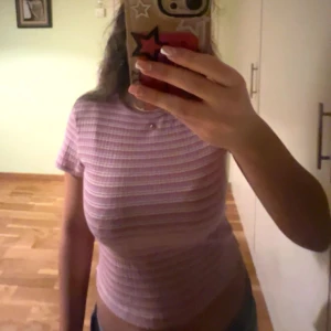 Rosa och vit randig topp från Nelly  - Säljer en söt rosa och vit randig topp från Nelly. Den är kortärmad och har en croppad passform. Toppen är gjord i ett mjukt och bekvämt material. 