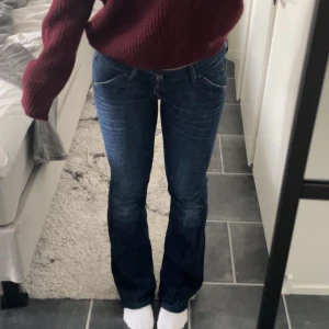 Lee Blå bootcut jeans - Lee Snygga blå bootcut jeans med låg midja. Perfekta för en avslappnad stil. De har en klassisk femficksdesign och stängs med dragkedja och knapp.