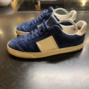 Valentino flycrews - Snygga blå sneakers från Valentino med vita detaljer och snörning. Skorna har en stilren design med en kontrasterande vit rand på sidan och små nitar på hälen. Perfekta för en trendig look. nypris 8000kr || mitt pris endast 3500kr