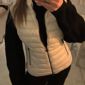 Vit colmar dunväst med dragkedja - Snygg vit dunväst med dragkedja framtill och två praktiska fickor med dragkedjor. Perfekt för lager-på-lager under kyligare dagar. storlek 44 men som en S,xs