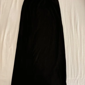 Svart ribbad kjol från Shein - Snygg svart ribbad kjol från Shein i storlek 10Y. Kjolen har en elastisk midja för bekväm passform och är perfekt för olika tillfällen. Den är enkel och stilren, vilket gör den lätt att matcha med olika toppar.