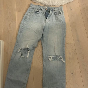 Ljusa jeans med slitningar från Perfect Jeans - Säljer ett par ljusa jeans från Gina tricot med coola slitningar på benen. De har en klassisk femficksdesign och stängs med dragkeoch knapp. Perfekta för en avslappnad stil.