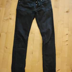 Säljer ett par svarta jeans från Nudie Jeans i storlek 30/32, model Tilted Tor. Pure black, innebär att dom inte bleks på samma sätt som ett par som är infärgade svary.. Perfekta för både vardag och fest!