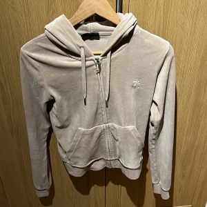 Juciy couture teöja - Säljer min beiga juciy kofta. Den har knappt kommit till andvändning men säljer den för lågt pris för att det inte finns så många intresserade. St xs, inga speciella deffekter som syns