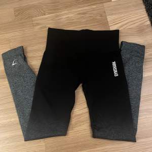 Säljer ett par snygga leggings från Gymshark i svart och grått. De är högmidjade och har en tight passform, perfekt för träning. Säljer då det inte passar längre. De är i storlek xs. Inga defekter förekommer. 