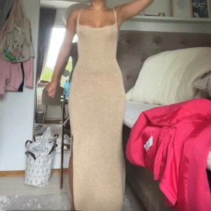 Guldig långklänning - Världens finaste långklänning i guldigt stickat material som är lite skimmrigt. Den är öppen i ryggen emd knytning som gör att man kan anpassa storleken. Köpt i split för ca 500kr❤️