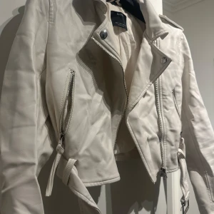 Vit skinnjacka från KappAhl - Super fin skinnjacka i vit från Berska. Finns en liten fläck på jackan men syns ej tydligt. Använd fåtal gånger