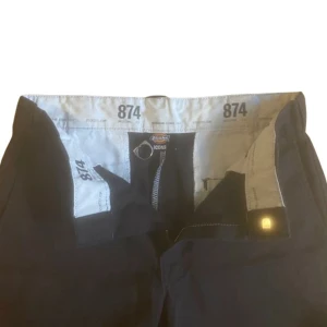 Dickies 874 - Tidslösa, populära chinos från dickies. Passar alla tillfällen, riktigt soft basplagg. Finns en liten reva på ena byxbenet, men är knappt märkbart. Står 32/30 på taggen men sitter mer som 30/30. Finns det frågor är det bara att skicka ett meddelande!