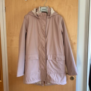 Regnjacka med teddyfoder - Oanvänd, rosa regnjacka med teddyfoder. Storlek 170 cl.