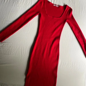Ribbad klänning  - Ribbad röd klänning från NA-KD. Använd ca 1 gång. Urringning med långa ärmar. Denna produkt är även väldigt stretchig. (Pris kan diskuteras)