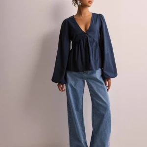 Blus  - Säljer en superfin mörkblå blus med v-ringning och långa ärmar. Blusen har en lös passform och knappar framtill som ger en snygg detalj. Perfekt för både vardag och fest! Använd endast en gång så är i nyskick💕priset kan diskuteras 