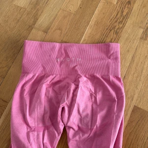Bubblegum seamless leggings från Nvgtn - Snygga rosa leggings från Nvgtn med hög midja och ribbad detalj vid midjan. De är stretchiga och bra form vid rumpan. Köpt för 760 kr