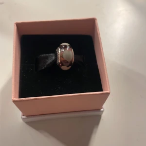 Silverfärgad berlock från Pandora - Elegant silverfärgad berlock från Pandora med hjärtan på. Perfekt för att komplettera ditt armband eller halsband. Kommer i en orginal ask.