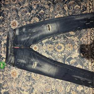 Snygga blå jeans från Dsquared2 med slitna detaljer och en cool, tvättad look. De har en klassisk femficksdesign och en tydlig logga på baksidan. Perfekta för en avslappnad stil med en touch av edge.