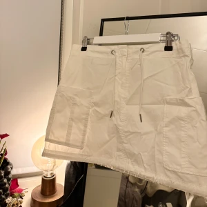 Vit kjol från & Other Stories - Snygg vit kjol från & Other Stories med fickor och justerbar i midjan. 