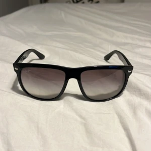 Svarta solglasögon från Ray-Ban - Snygga svarta solglasögon från Ray-Ban med en klassisk design. Modellen RB 4147 har en bred båge och mörka tonade glas. Perfekta för soliga dagar och ger en stilren look. Men har tyvärr inte boxen till dom men hoppas det går bra ändå 