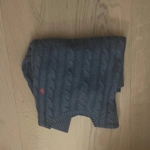 Grå och svart kabelstickad tröja från Ralph Lauren - Säljer två kabelstickade tröjor från Ralph Lauren i blå och mörk blå . Tröjorna har en klassisk design med rund hals och ett diskret logotypbroderi. Perfekta för kyligare dagar. Helt oanvända 1000kr styck pris kan diskuteras 