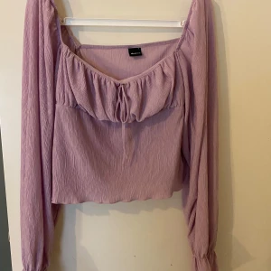 Lila blus/tröja - Säljer denna somriga tröja med fina detaljer o ribbat mönster. Använd fåtal gånger, Stl L men funkar för en som har Stl m oxå