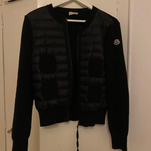 Moncler Padded Wool Zip-up cardigan - Säljer nu min svarta Moncler Padded wool zip-up Cardigan, då den aldrig kommer till användning. Jackan är i mycket fint skick, har även kvittot kvar! Storlek M, men passa mig som har storlek S också, den är stretchig i och med tyget där bak. Hör av er vid frågor eller funderingar❤️Nypris:9505:-