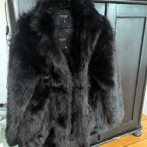 Svart pälsjacka från  - Säljer min fluffiga svarta jacka då den inte kommer till användning. Helt ny då lapparna finns kvar och inga anmärkningar.