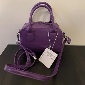 Väska - Oanvänd lack lila väska från Carin Wester.