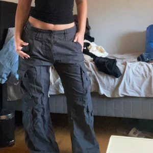 Cargobyxor - Säljer ett par svarta cargobyxor i loose fit. De har flera praktiska fickor och en knytning i midjan för justerbar passform. Köpt här på plick men har aldrig kommit till användning, mycket bra skick. Kontakta mig vid frågor💕
