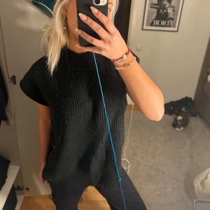 Svart ribbad tröja - Säljer en svart ribbad tröja i mycket bra skick. Den har en loose passform och kortärmade ärmar, perfekt för både höst och vår. Tröjan är stilren och enkel att matcha med olika outfits. Perfekt för en avslappnad look!