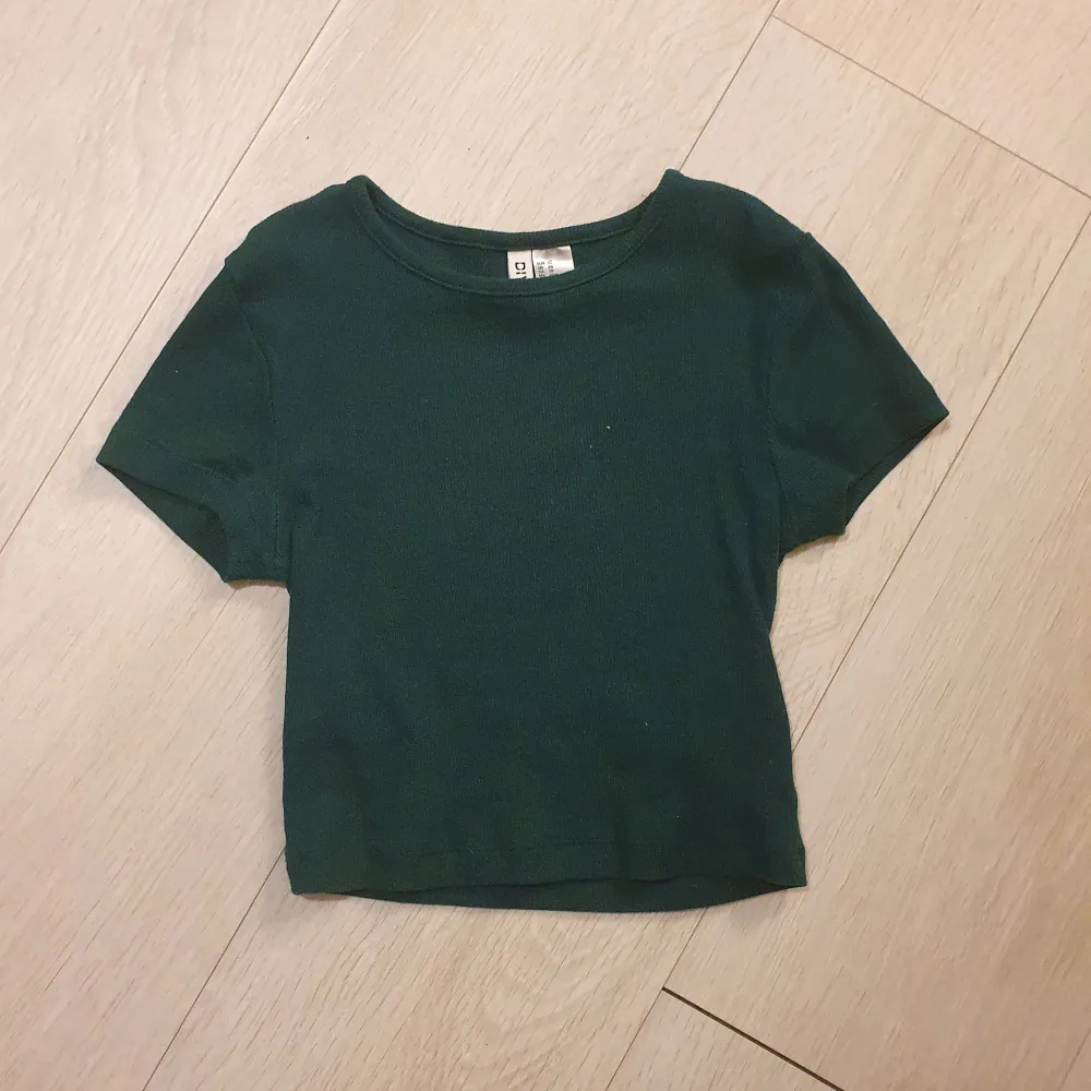 Säljer en mörkgrön kortärmad topp från H&M Divided i storlek XS. Den har tight passform och säljer eftersom att dem inte används❤️❤️Skriv förfler bilder/frågor!. Toppar.