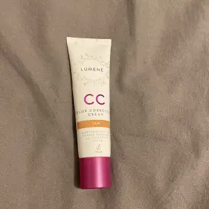 Säljer en Lumene CC Color Correcting Cream i nyansen Tan. Denna kräm jämnar ut hudtonen och ger medium täckning med SPF 20. Perfekt för en naturlig look och skydd mot solen. Tuben är 30 ml och har en praktisk skruvkork i rosa.