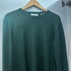 Mörkgrön tröja från Les Deux - Säljer en stilren mörkgrön tröja från Les Deux i mycket bra skick. Tröjan är långärmad och har en enkel design med rund halsringning. Perfekt för både vardag och lite finare tillfällen. Passar bra till höst och vinter! Sitter som S/M