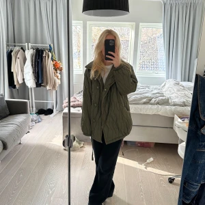 Odd Molly Olivgrön quiltad jacka - Säljer en superfin olivgrön quiltad jacka från Odd Molly. Den har en oversized passform och knappar framtill. Perfekt för höst och vår när du vill vara både varm och stilren. Jackan är i bra begagnat skick och har en unik design med vågigt quiltmönster. Storlek 2, ungefär M. Lite smutsig här och där men inget som syns så tydligt. Nypris är 3795kr